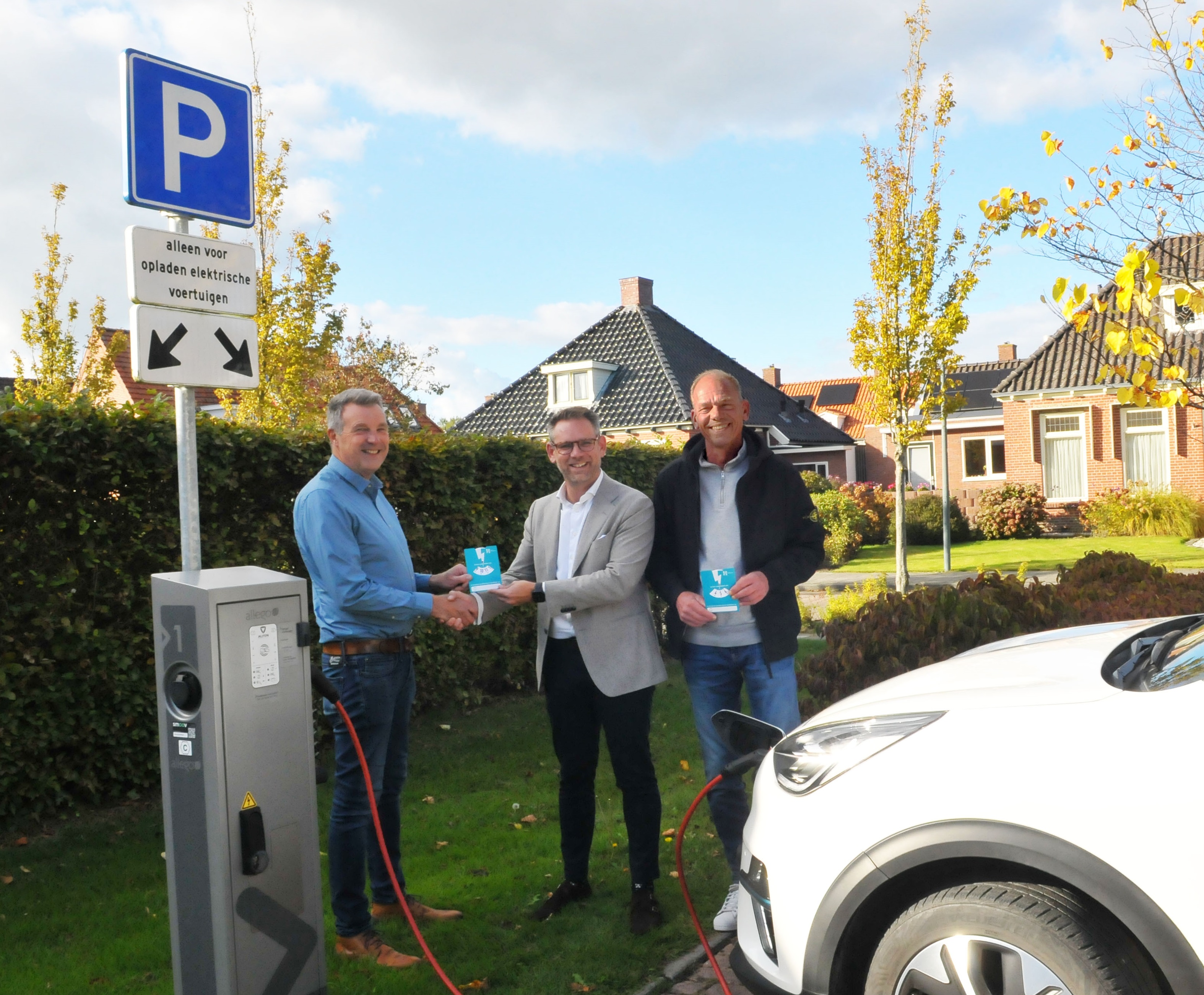 Foto: wethouder overhandigt laadschijf aan inwoner