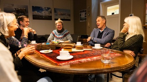 Foto burgemeester en bewoners rond tafel